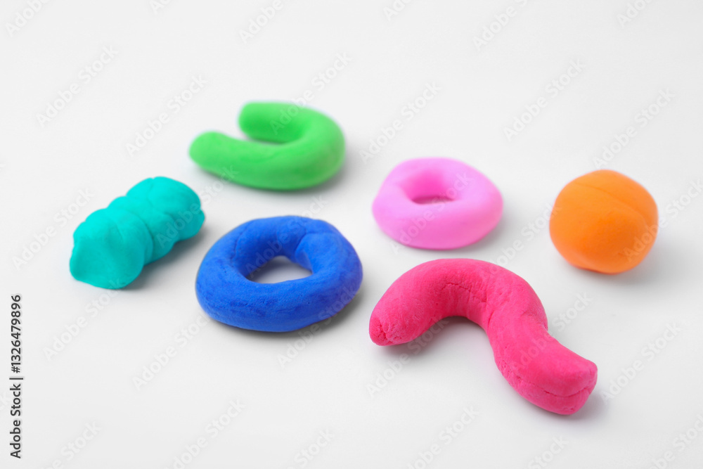 Naklejka premium Different colorful play dough on white background, closeup