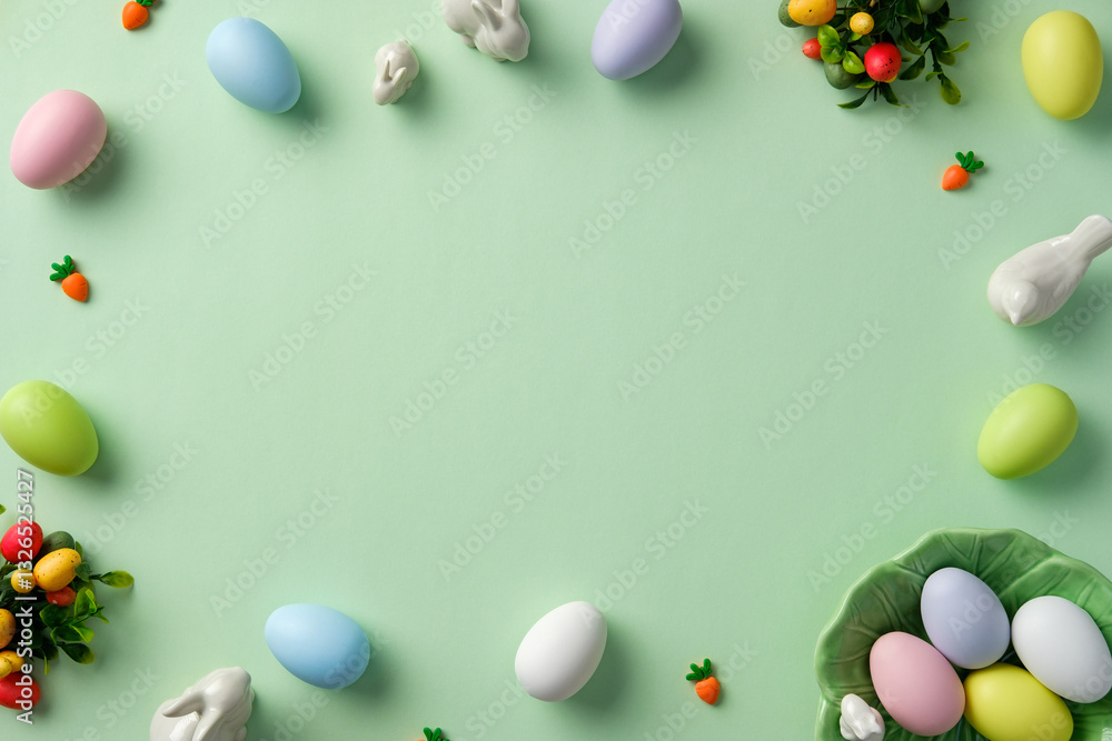 Easter greeting card template. Top view frame of pastel Easter eggs, bunny, decorations on light green background Easter greeting card template. Top view frame of pastel Easter eggs, bunny, decorations on light green background