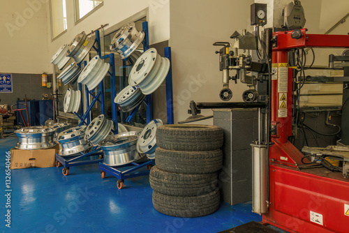 Canvas Print View of a haphazard display of car and truck wheels, and some machinery, at an auto repair shop in the town of Moniquirá, in the central Andean mountains of Colombia