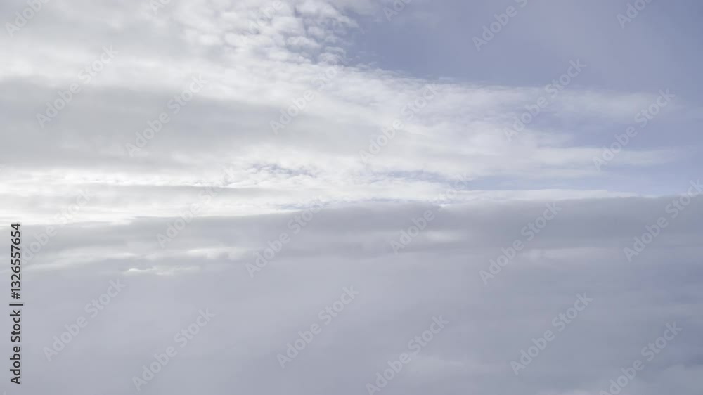 a dynamic aerial view of the sky, filled with layers of soft, billowing clouds. The upper portion reveals glimpses of a vibrant blue sky, contrasting with the denser, grayish-white clouds below. a dynamic aerial view of the sky, filled with layers of soft, billowing clouds. The upper portion reveals glimpses of a vibrant blue sky, contrasting with the denser, grayish-white clouds below.