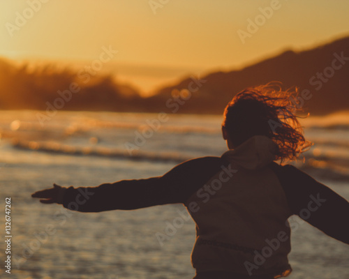 mulher correndo na beira do mar em amanhecer em praia da pinheira, santa catarina 
