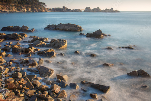 Coast of Korea with round rock formations, a long exposure sea water at sunrise with some vegetation on the shore