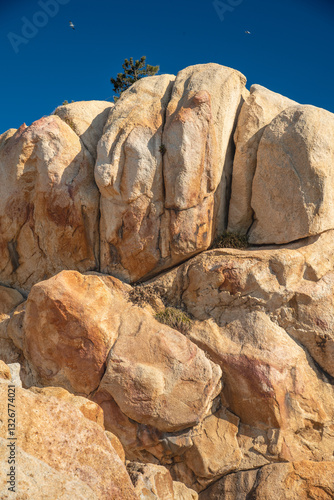 Natural rock formation with soft sunlight with a stripe of blue sky and birds