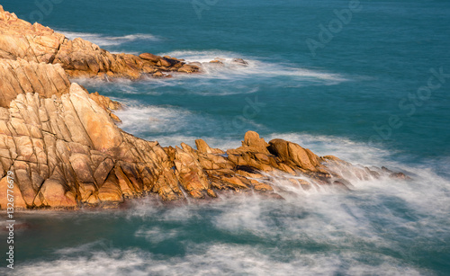 Rocky sea coast line with long time exposed waves in the morning