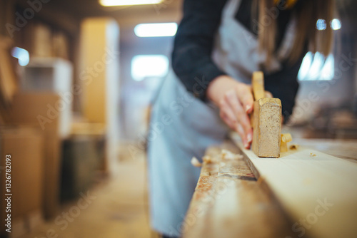 Obraz na plátne Craftsman Hand Using a Wood Plane in Workshop Environment