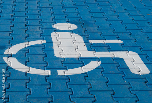 A blue pavement features a white accessibility symbol, highlighting a space designed to support individuals with mobility challenges in a community setting photo