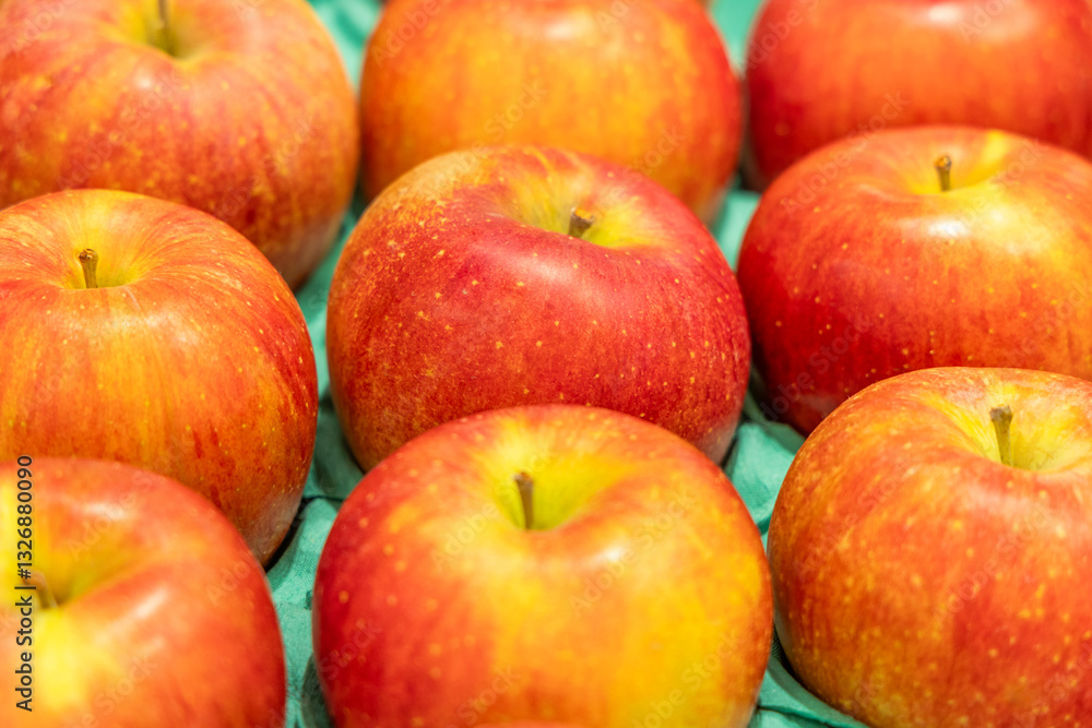 Ripe apples with a rich red and yellow gradient displayed in a fruit market, emphasizing their freshness, organic quality, and appealing appearance