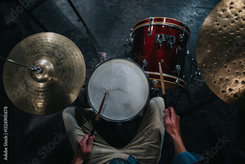 фотографія An overhead shot capturing a musician playing a drum set, showcasing the performance energy and rhythm