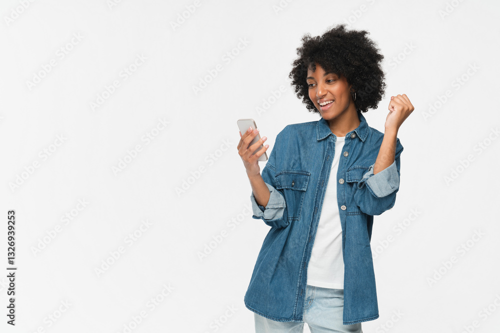 Excited crazy gen z african young woman girl winner with smartphone happy shopper customer female student screaming yes using mobile cell phone celebrating online prize win on white background. Excited crazy gen z african young woman girl winner with smartphone happy shopper customer female student screaming yes using mobile cell phone celebrating online prize win on white background.