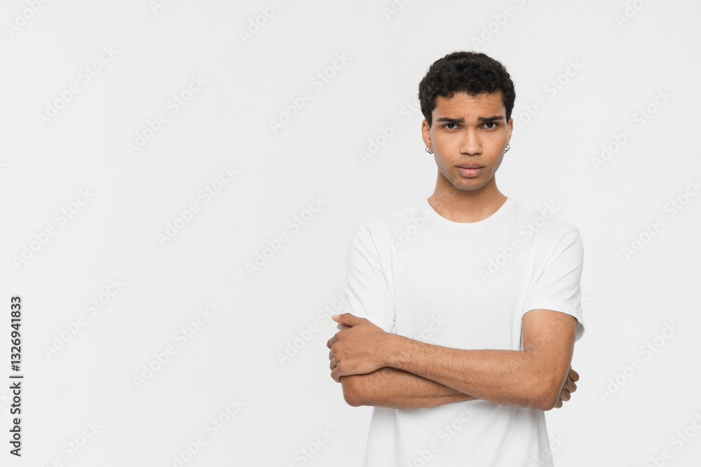 Serious confused displeased young african american man 20s years old wearing basic casual standing and looking camera isolated on white color wall background, studio portrait copy empty space Serious confused displeased young african american man 20s years old wearing basic casual standing and looking camera isolated on white color wall background, studio portrait copy empty space