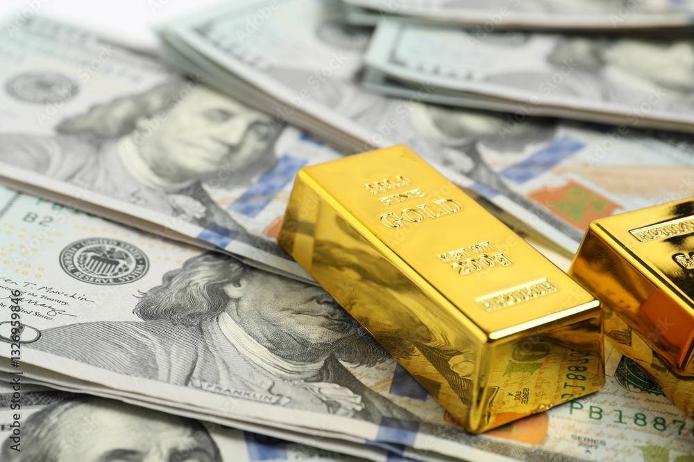 Shiny gold bars on dollar banknotes, closeup. Space for text Shiny gold bars on dollar banknotes, closeup. Space for text