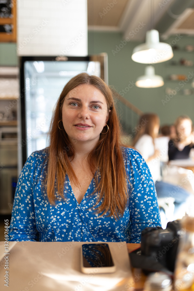 Happy redhead 30s Woman waiting at table in cafe.