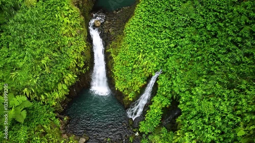 Aerial view of a breathtaking waterfall cascading through lush greenery in a tropical forest, Apia, Tuamasaga, Samoa.