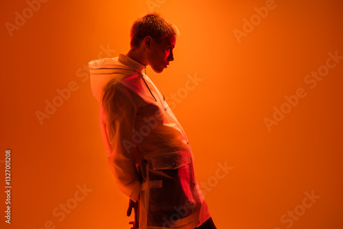 A modern portrait showcasing a person wearing a transparent jacket, set against a vivid orange background, emphasizing vibrant colors, contemporary fashion, and the subject's intriguing silhouette and