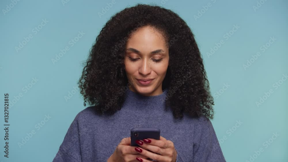 Smiling woman using smartphone on blue background Smiling woman using smartphone on blue background