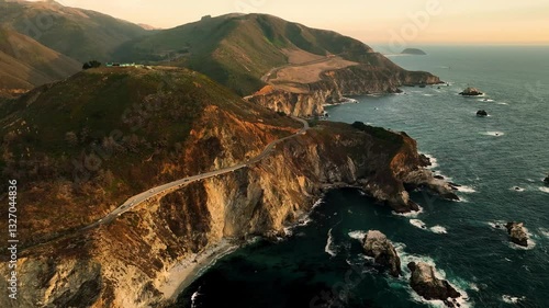 Aerial view of bixby creek bridge at sunset surrounded by fog over the rocky coast, Big Sur, California, United States.