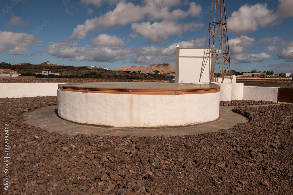 Antiguo aljibe redondo de piedra con muros para proteger el agua. Fuerteventura, La Oliva.