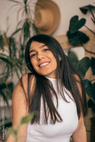 Obraz na płótnie Portrait of a happy young dark-haired woman in a room with indoor plants. w salonie