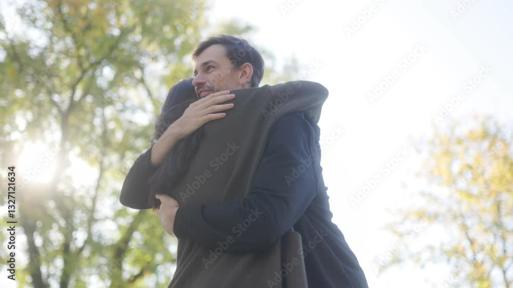Joyful Autumn Reunion as Couple Embraces in a Park Setting Joyful Autumn Reunion as Couple Embraces in a Park Setting