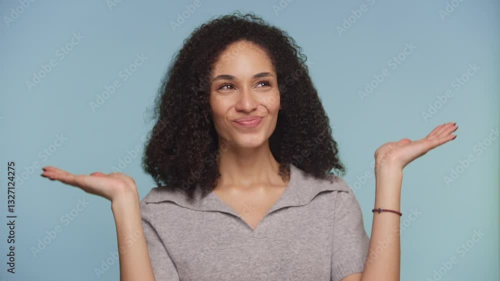 Woman weighing options with thoughtful expression on blue background Woman weighing options with thoughtful expression on blue background