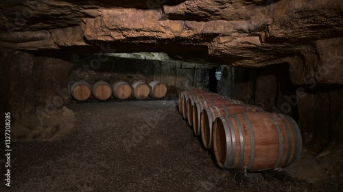 Aged wooden barrels with a wine in a former stone quarry, row of wine barrels at a vintage winery, Wine preparation and fermenting process, High quality 4k footage