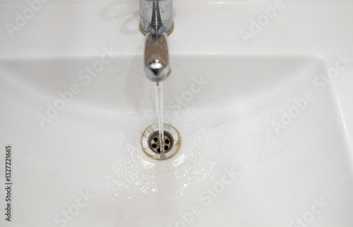  A white sink in the bathroom or toilet with cracks in the form of a spider web.