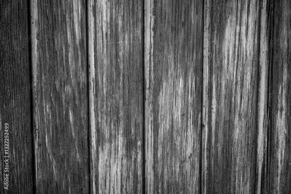 Fototapeta premium A close-up of weathered wooden planks showing a range of grays, creating a textured black and white effect.