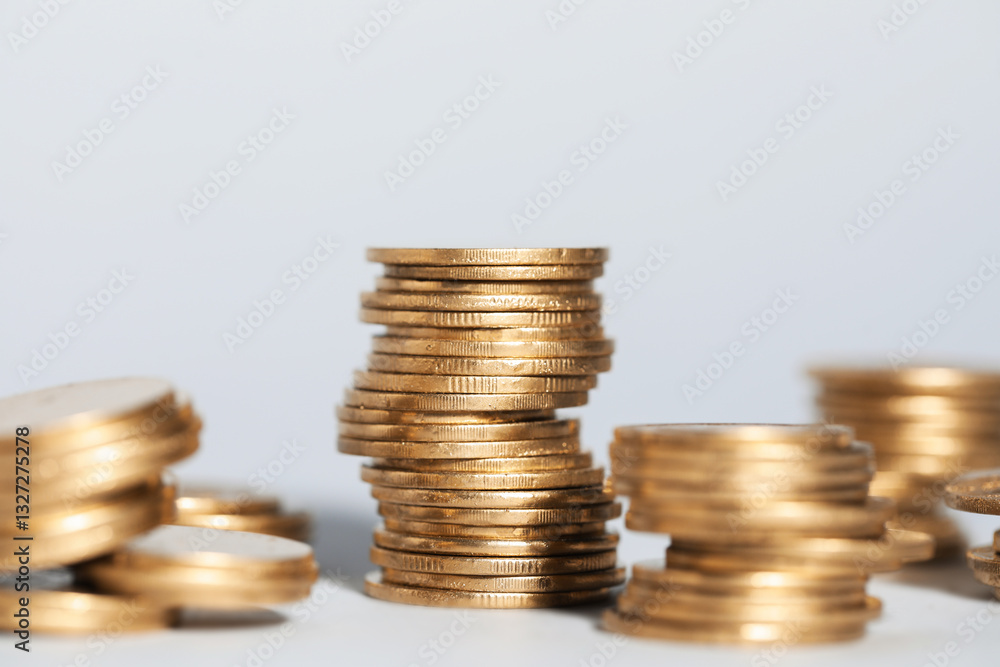 Many stacked coins on light grey background, closeup Many stacked coins on light grey background, closeup