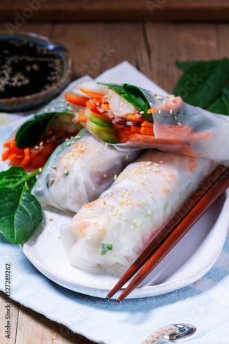 Obraz na płótnie Summer or spring rolls with shrimp, vegetables and spinach, served with soy sauce and sesame. Traditional Vietnamese food. w salonie