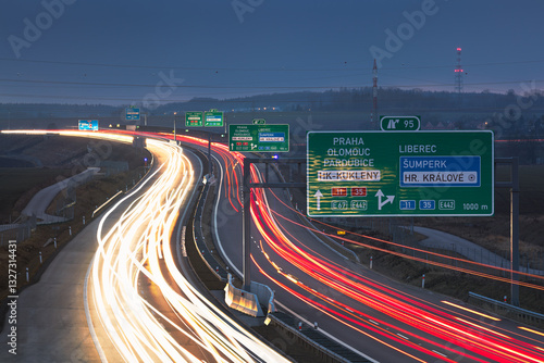 Highway D11 near exit 95, Hradec Králové, during evening rush hour, with long exposure of moving cars, traffic signs visible. photo