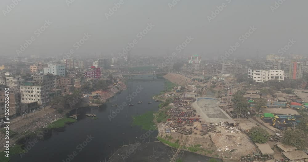 Aerial view of the bustling cityscape along the Buriganga river with high-rise buildings and traffic, Dhaka, Dhaka Province, Bangladesh. Aerial view of the bustling cityscape along the Buriganga river with high-rise buildings and traffic, Dhaka, Dhaka Province, Bangladesh.