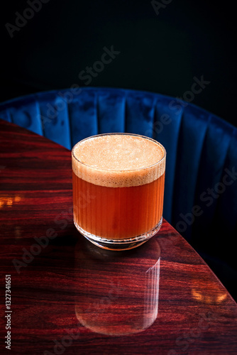 An alcoholic foamy cocktail in a lowball rocks glass