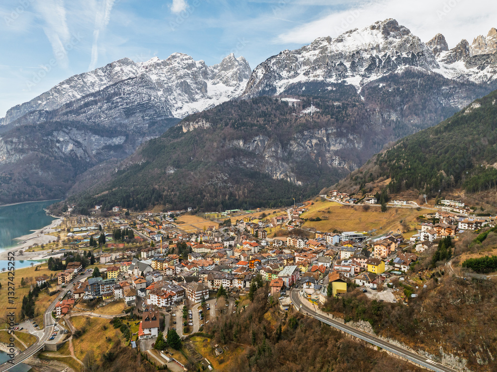 Obraz premium Aerial drone view of Lake Molveno, beautiful lake in Italy. Lake in dolomites from drone in winter. Lake Molveno in Italy. Sailboat, yacht on crystal clear lake in the Brenta Dolomites