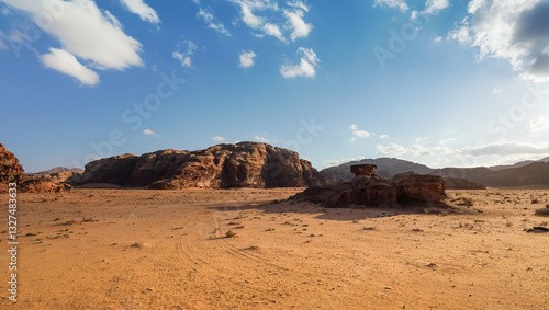 Obraz na płótnie Orange red sand desert, rocky formations and mountains background, blue sky above - typical scenery in Wadi Rum, Jordan w salonie