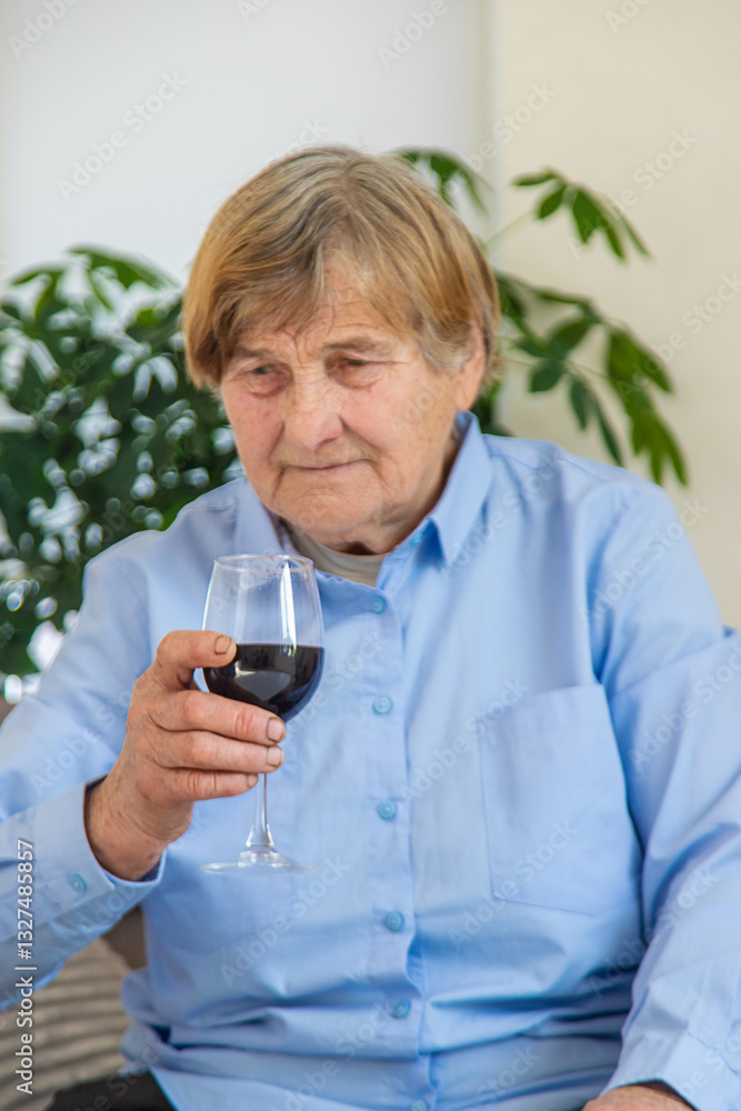 Old woman drinking wine. Selective focus. Old woman drinking wine. Selective focus.