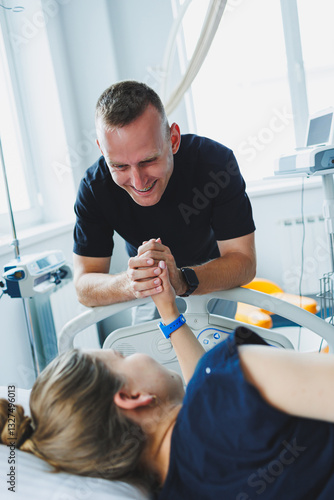 Obraz na płótnie Happy family couple in the delivery room preparing for the birth of a child. The woman lies in bed and gives birth to a child. A caring husband supports his wife during childbirth. w salonie