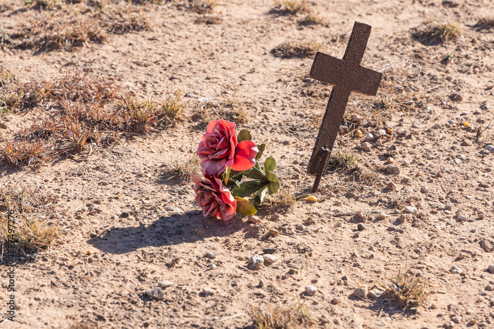 Rusted old unmarked cross in a rural graveyard.