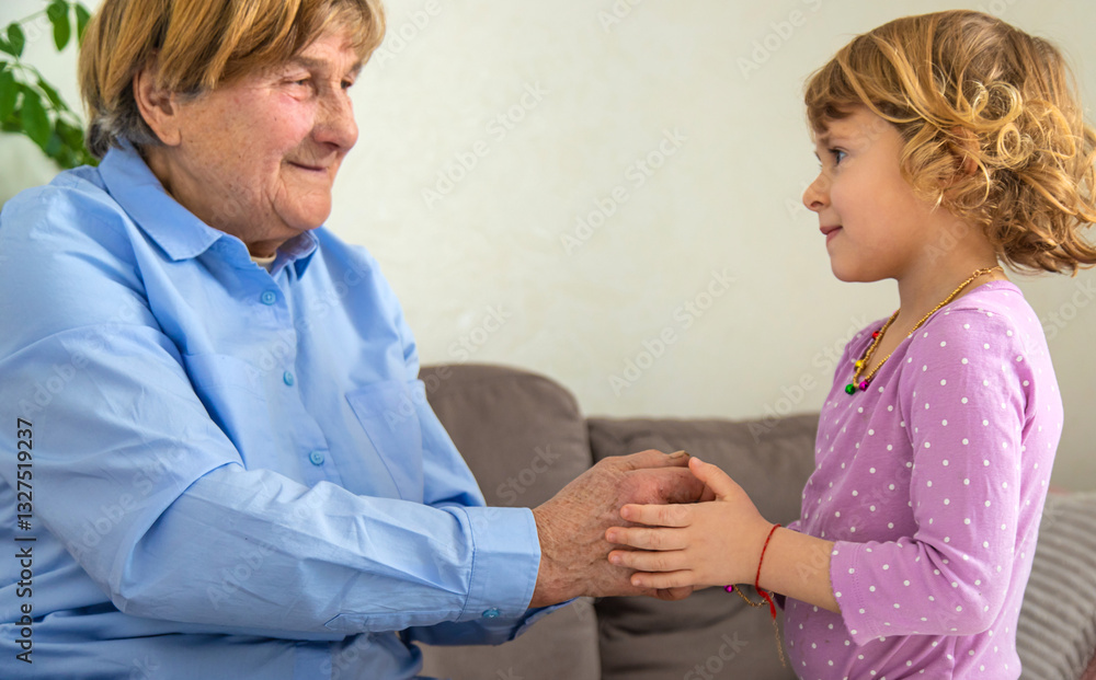 Fototapeta premium Old woman with her granddaughter. Selective focus.