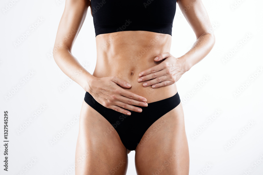 Fototapeta premium Beautiful woman with sporty body posing over white background.