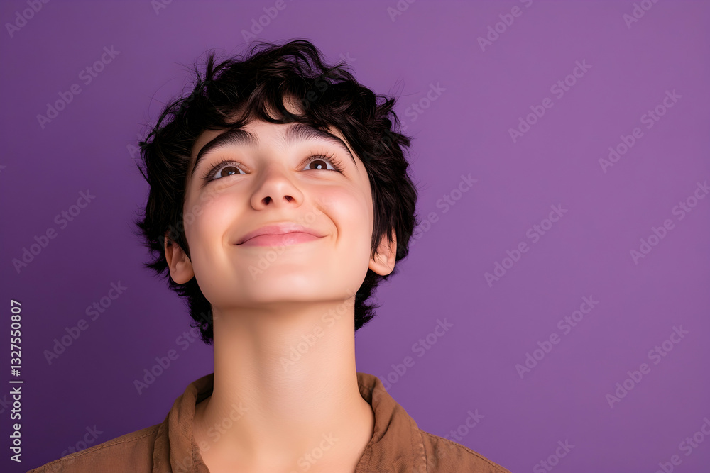 Happy person smiling and looking upward in thought, captured against a solid purple background Happy person smiling and looking upward in thought, captured against a solid purple background