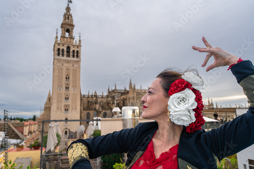 Mujer típica española bailando flamenco con una torre medieval y el cielo a su espalda. Desde la ciudad de Sevilla, Andalucía, España, Europa.	