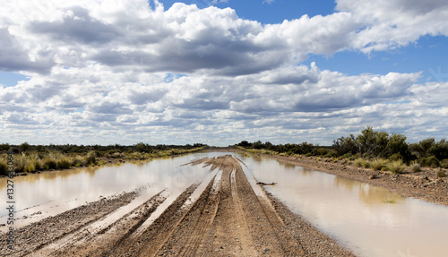 Fotografie Section of a gravel road in Argentine Patagonia with a large expanse of stagnant