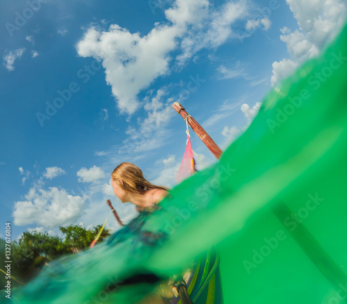 Obraz na płótnie Woman tourist relaxing on a hammock above the turquoise waters of Lake Bacalar, Mexico. Peaceful retreat, tropical paradise, and relaxation concept in a serene natural setting w salonie