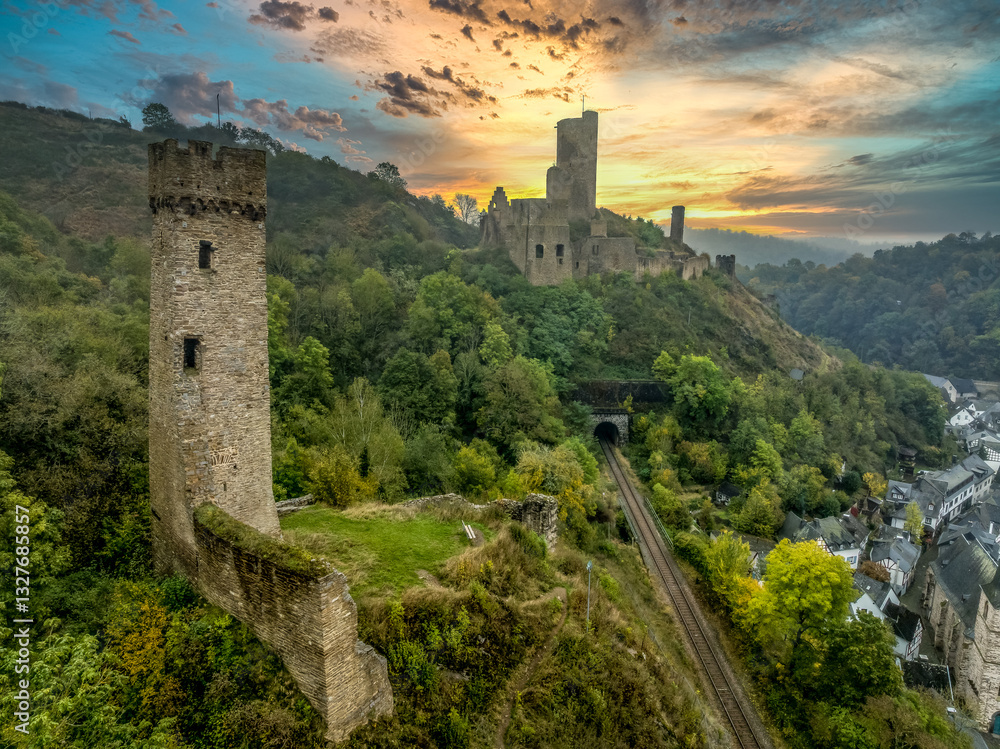 Aerial view of twin castles Philippsburg and Löwenburg above Monreal in Germany with tall keep sunset sky