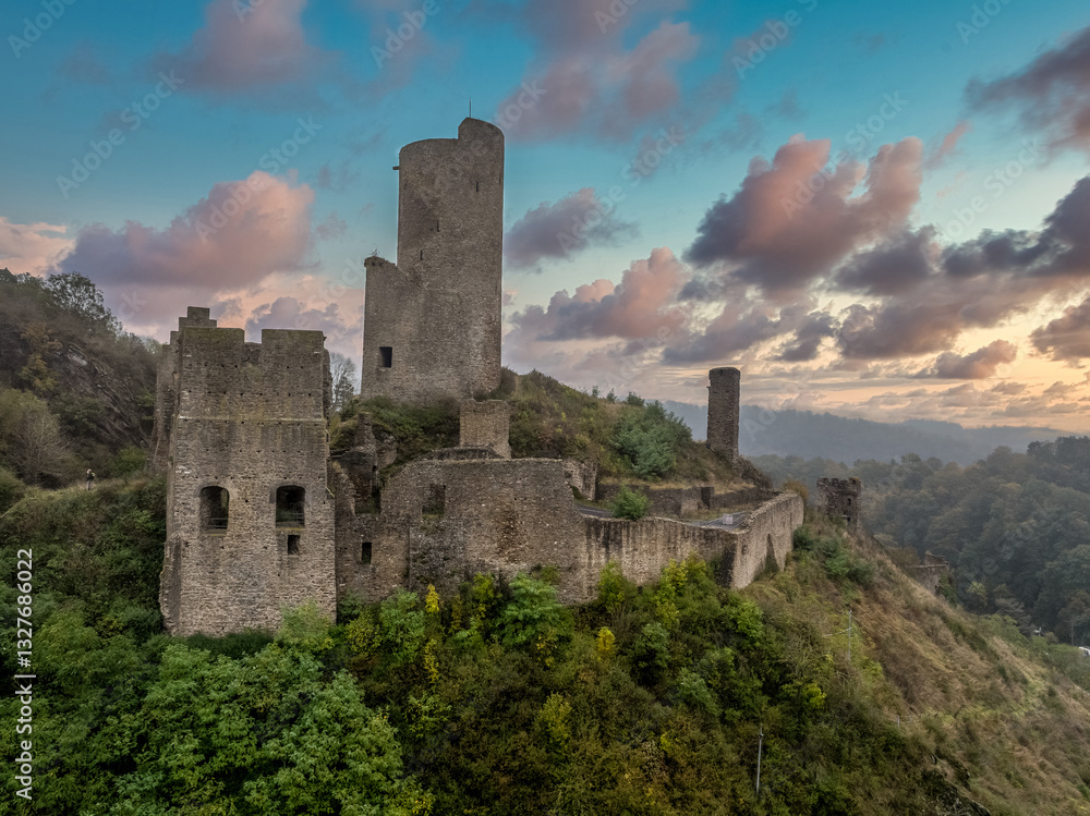 Aerial view of Philippsburg castle above Monreal in Germany with tall keep sunset sky