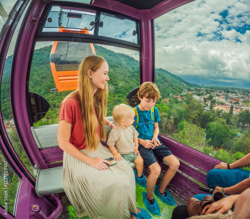 Mother and two sons on a cable car ride in Orizaba, Mexico. Scenic family adventure with panoramic views of the city, lush mountains, and iconic landscapes. Concept of family bonding, travel, and