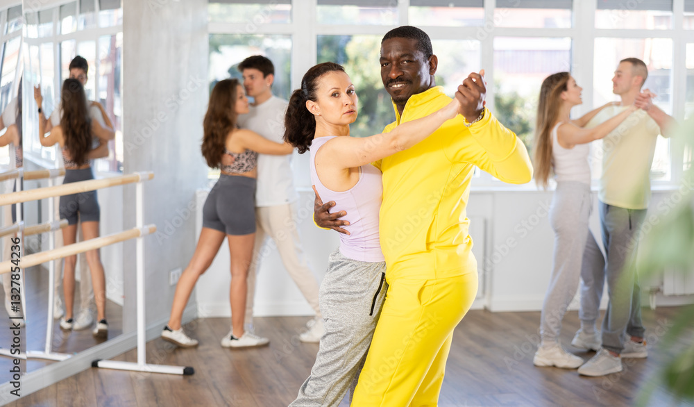 Naklejka premium Adult man and adult woman dance ballroom dance waltz in studio