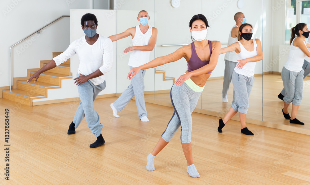 People in protective masks learning swing steps at class People in protective masks learning swing steps at class