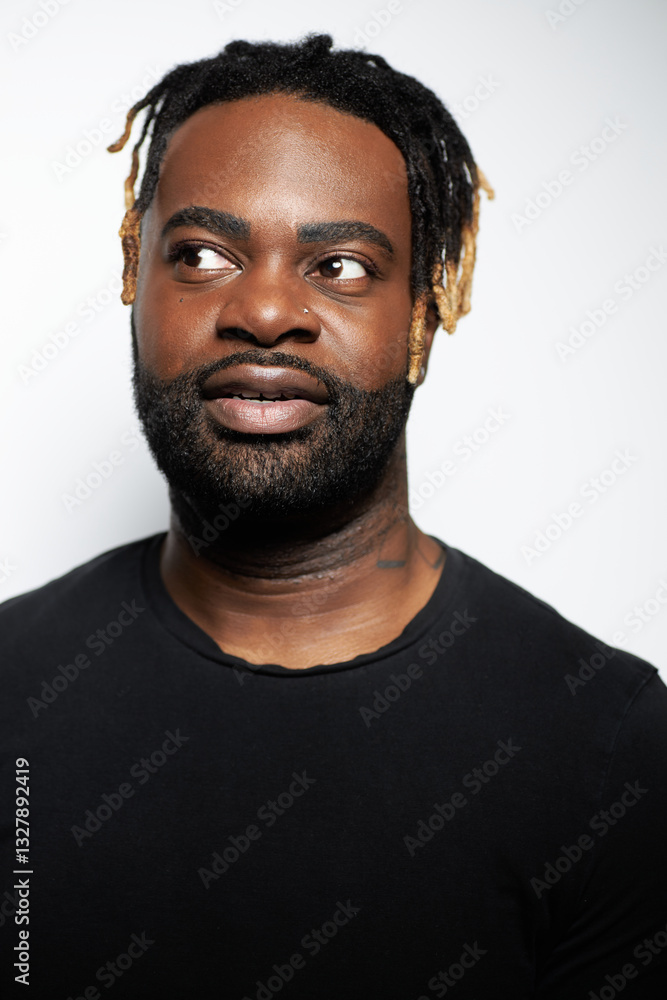 Portrait of a confident Black man with well-groomed beard wearing a denim shirt against a white background Portrait of a confident Black man with well-groomed beard wearing a denim shirt against a white background