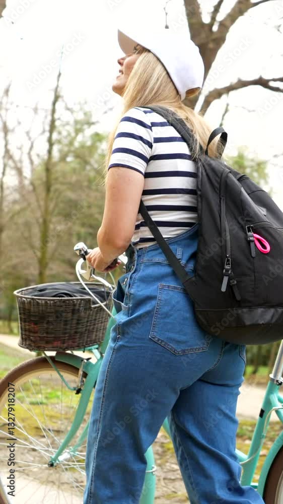 Young woman walking with her bicycle in a park Young woman walking with her bicycle in a park